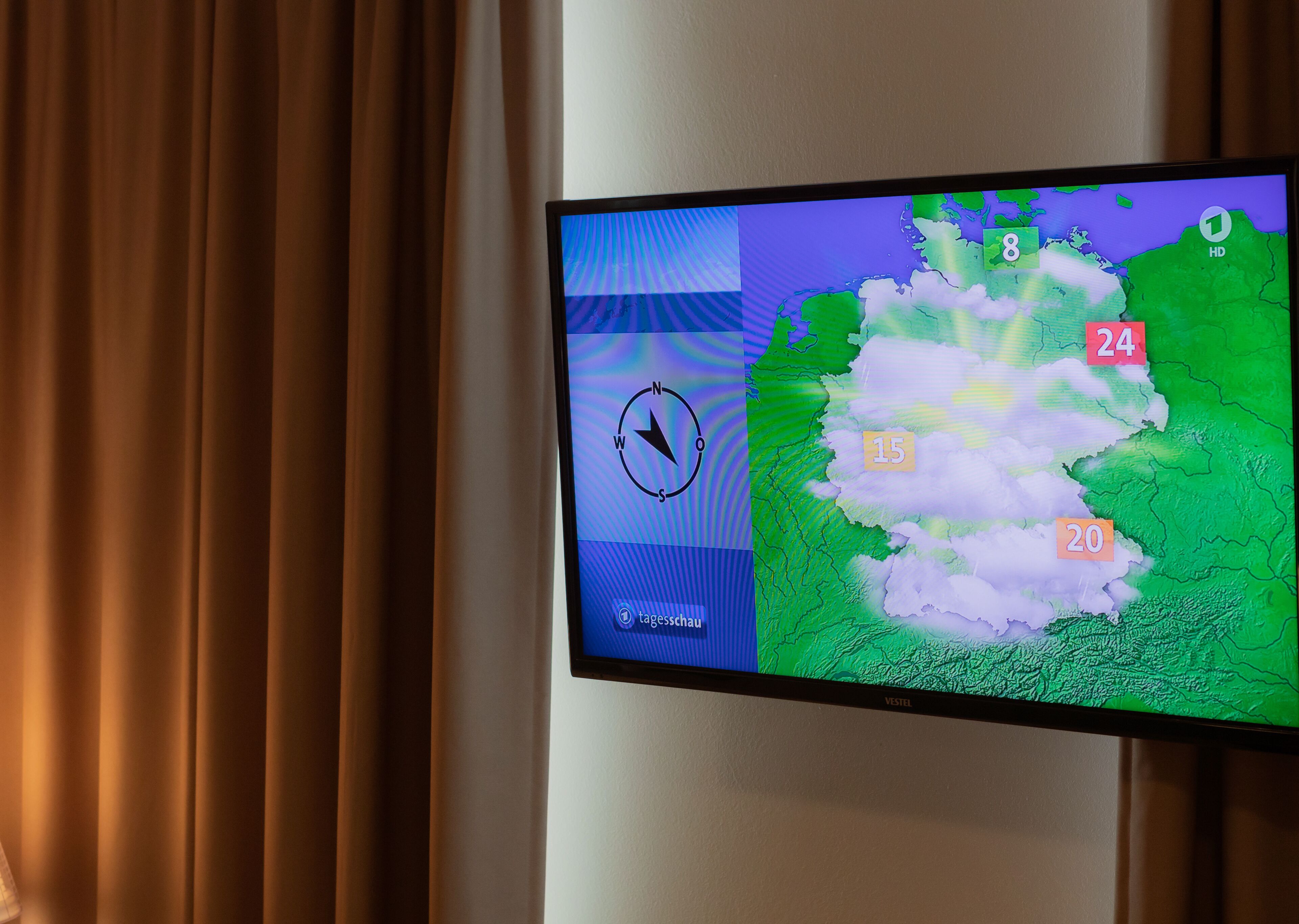 A television displaying a weather forecast with a map and temperature readings.