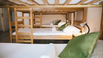 A bunk bed with wooden frames and white bedding.