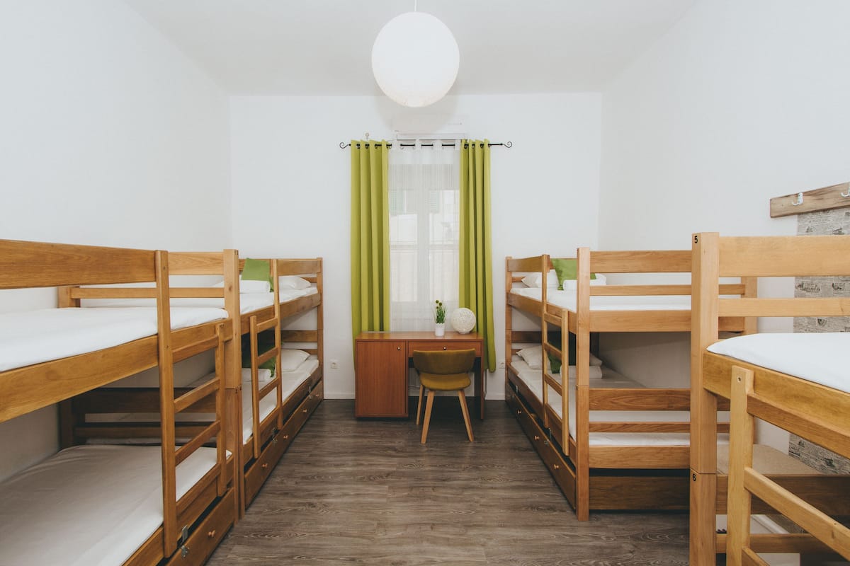 Asuntolan huone, jossa on kerrossängyt, työpöytä ja tuoli.