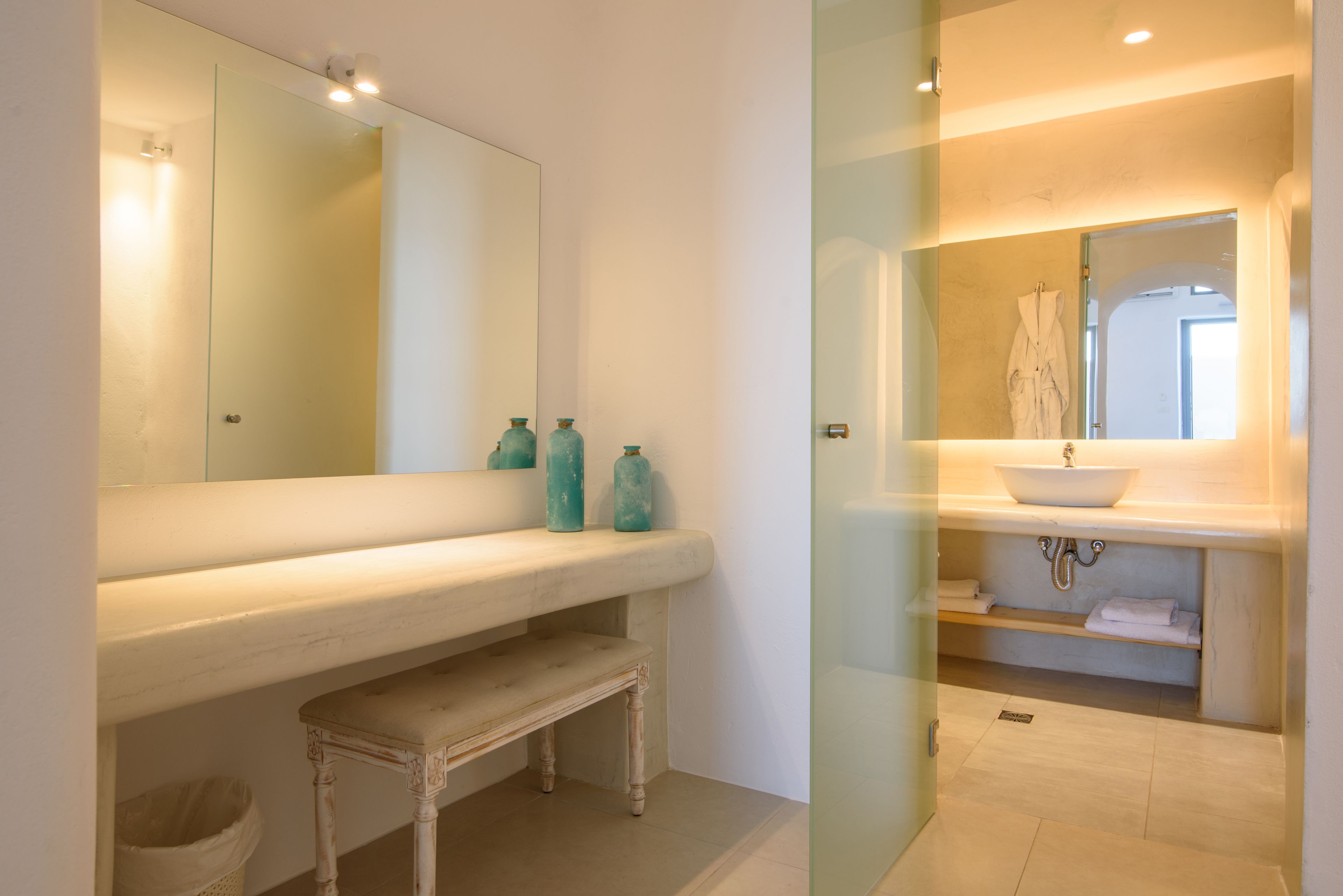 A bathroom with a large mirror, a white sink, and a glass shower enclosure.