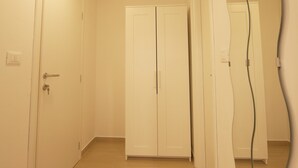 Un corridoio con porte bianche, un lampadario e uno specchio che riflette parte della stanza.