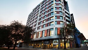 Un hotel de varios pisos con un diseño moderno, que destaca por su fachada curva y un letrero que dice "Golden Tulip".