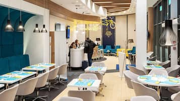Un vestíbulo de hotel moderno con un área de estar central, una recepción y una decoración con temática de bicicletas.