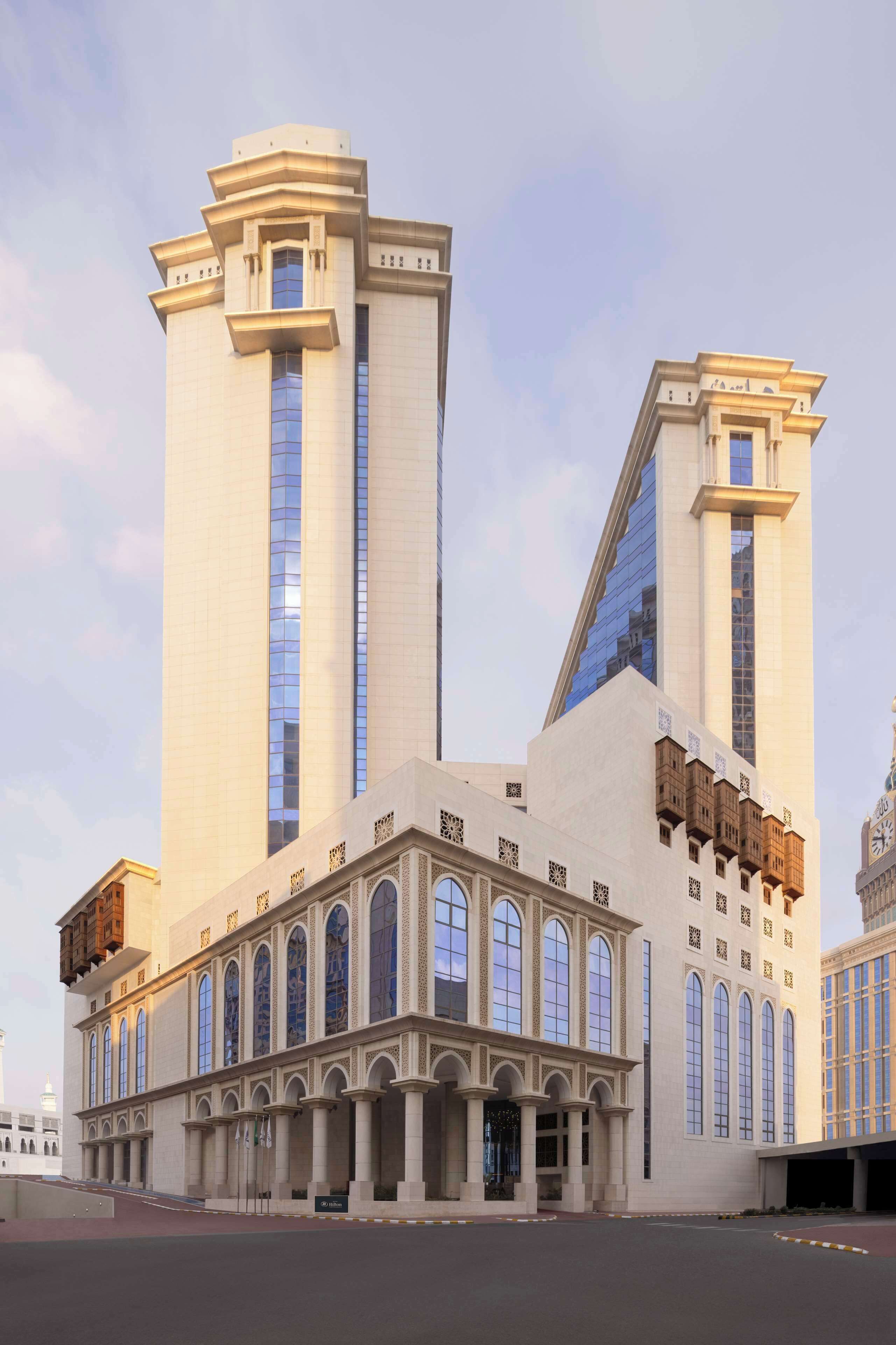 A large, modern building with two tall towers and a central section with arched windows and columns.