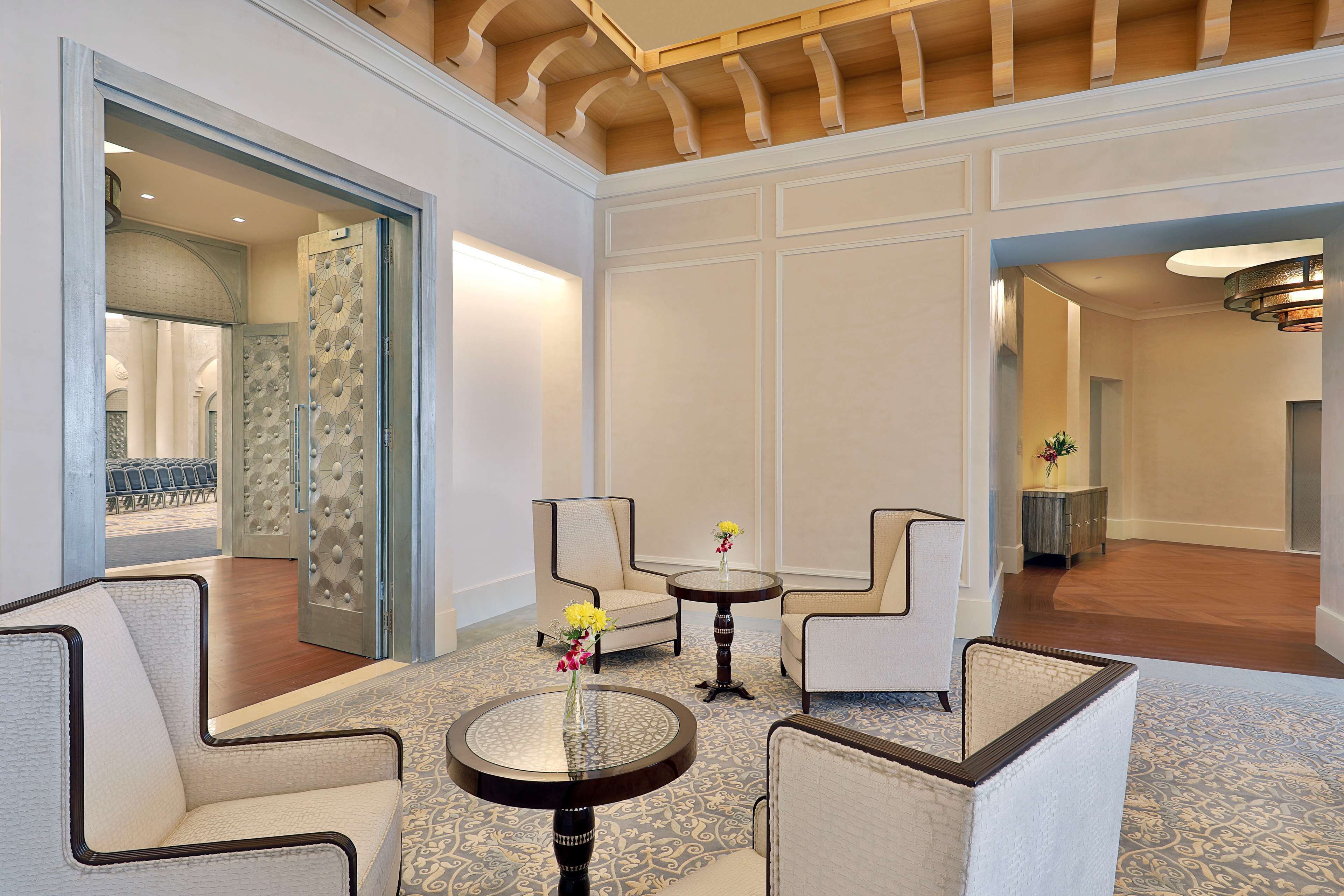A spacious lobby with high ceilings, elegant furniture, and a patterned carpet.