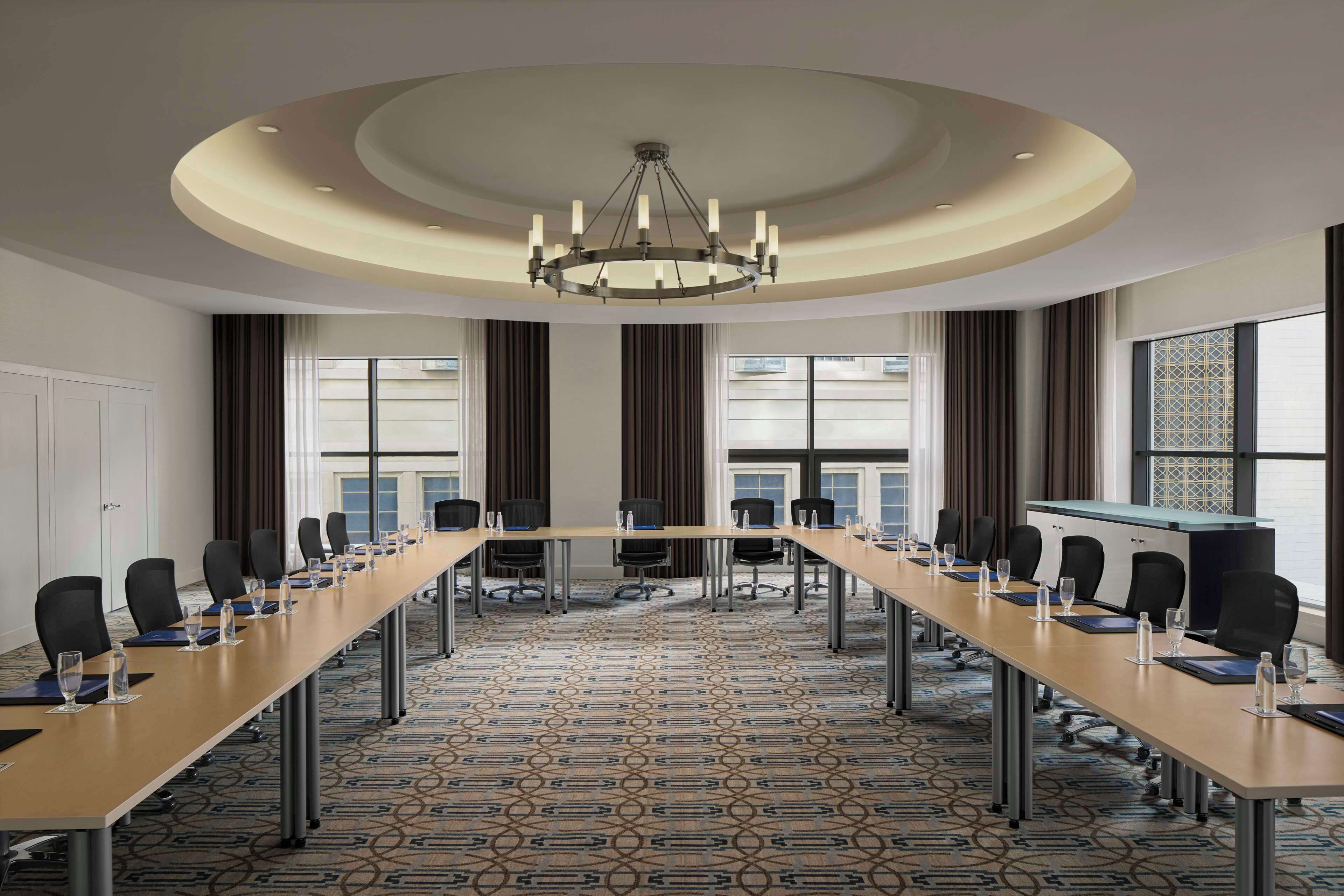 A conference room with a long table, chairs, and a chandelier.