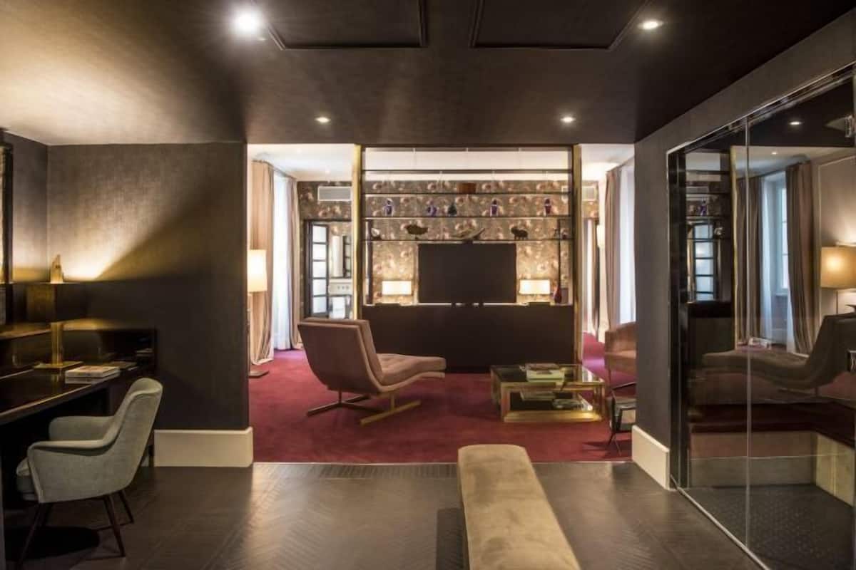 A modern living room with a red carpet, a glass partition, and a fireplace.