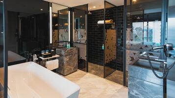 Un baño moderno con una bañera grande, un tocador con espejo y una zona de ducha.