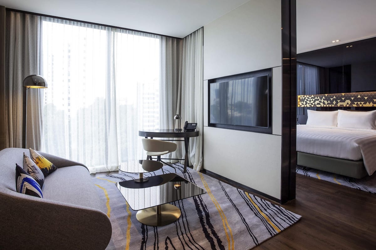 Une chambre d’hôtel moderne équipée d’un lit, d’un bureau, d’une chaise, d’une télévision et offrant une vue sur la ville.