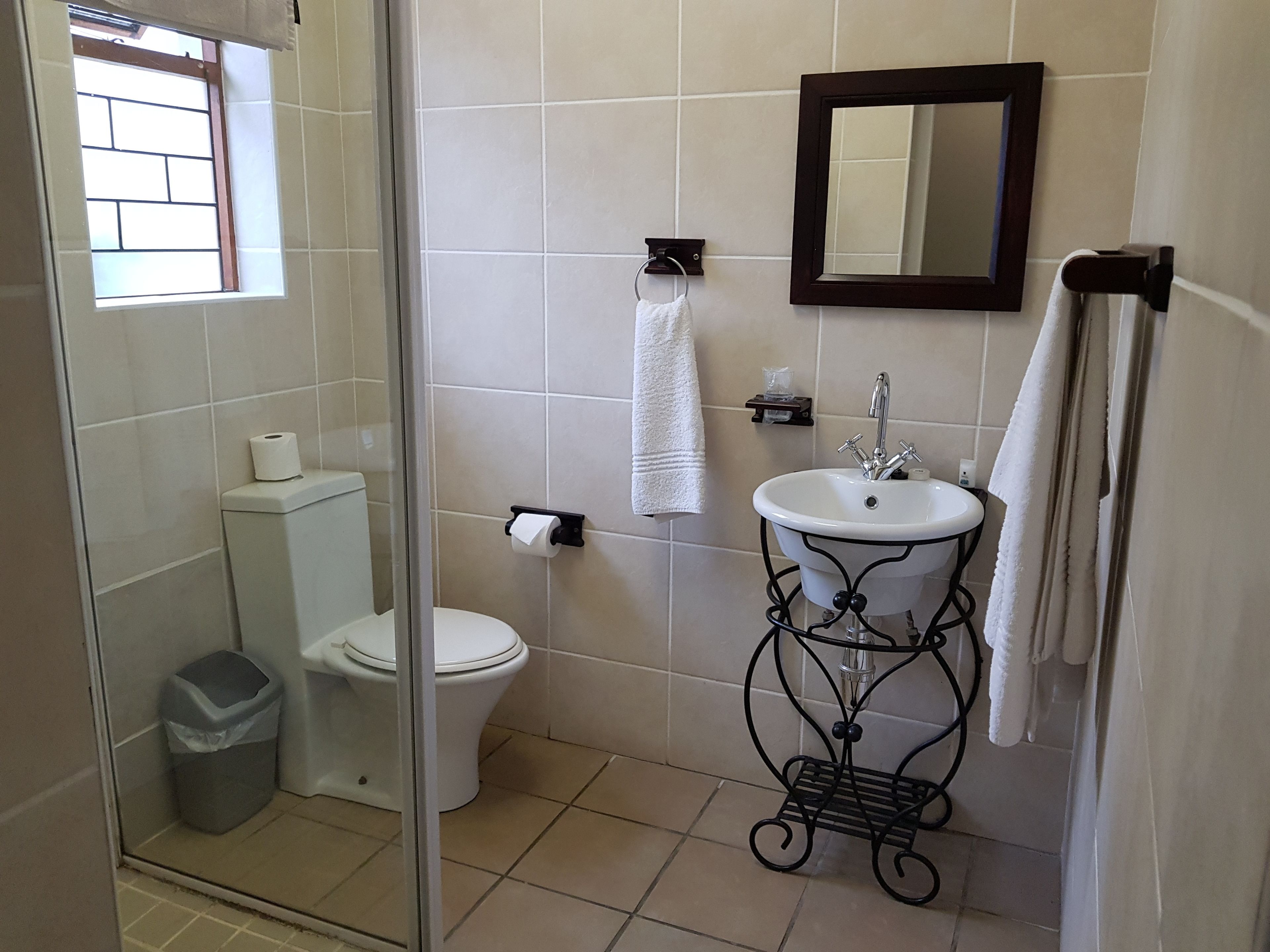 A bathroom with a toilet, sink, and shower area.