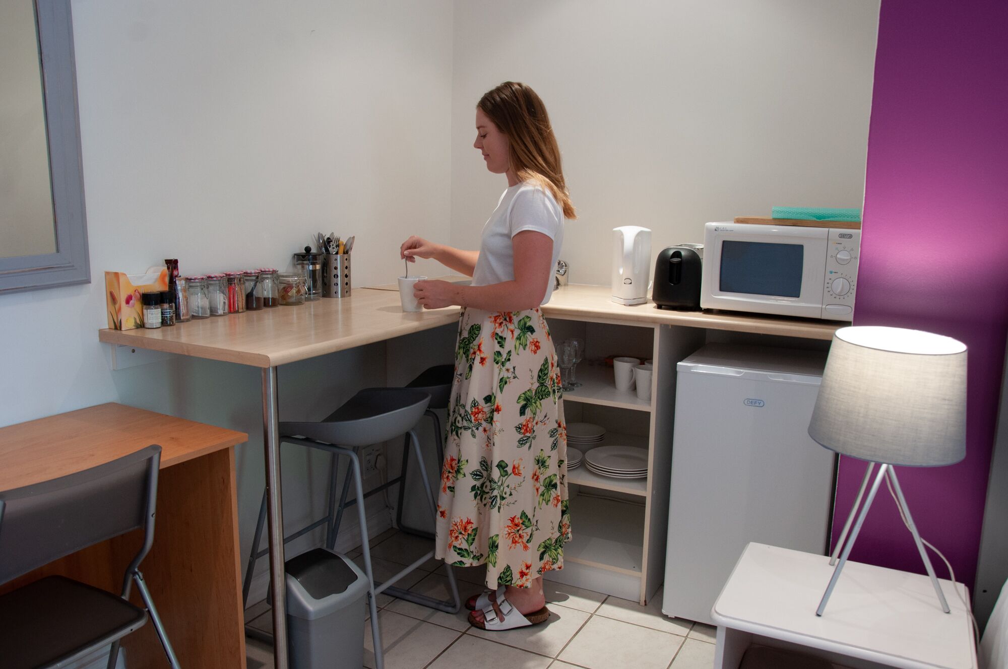 A compact kitchenette with a microwave, coffee maker, and various kitchen utensils.
