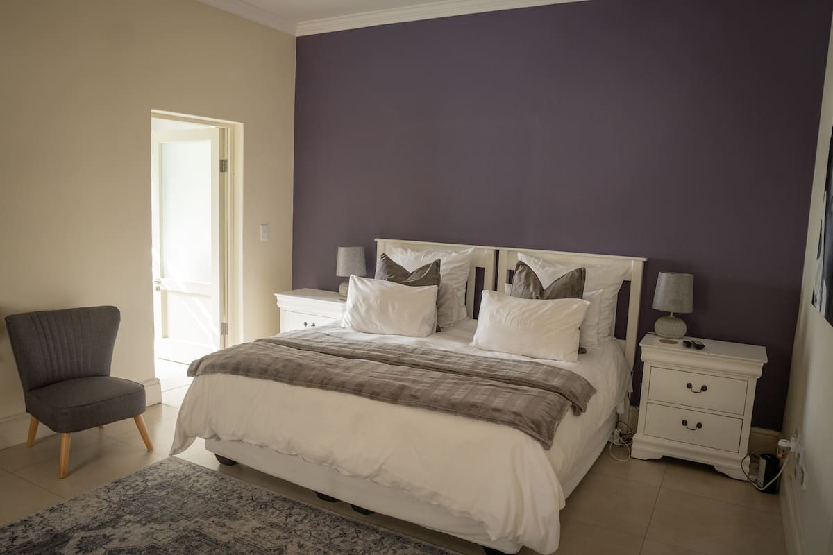 A bedroom with a bed, nightstands, a chair, and a rug.