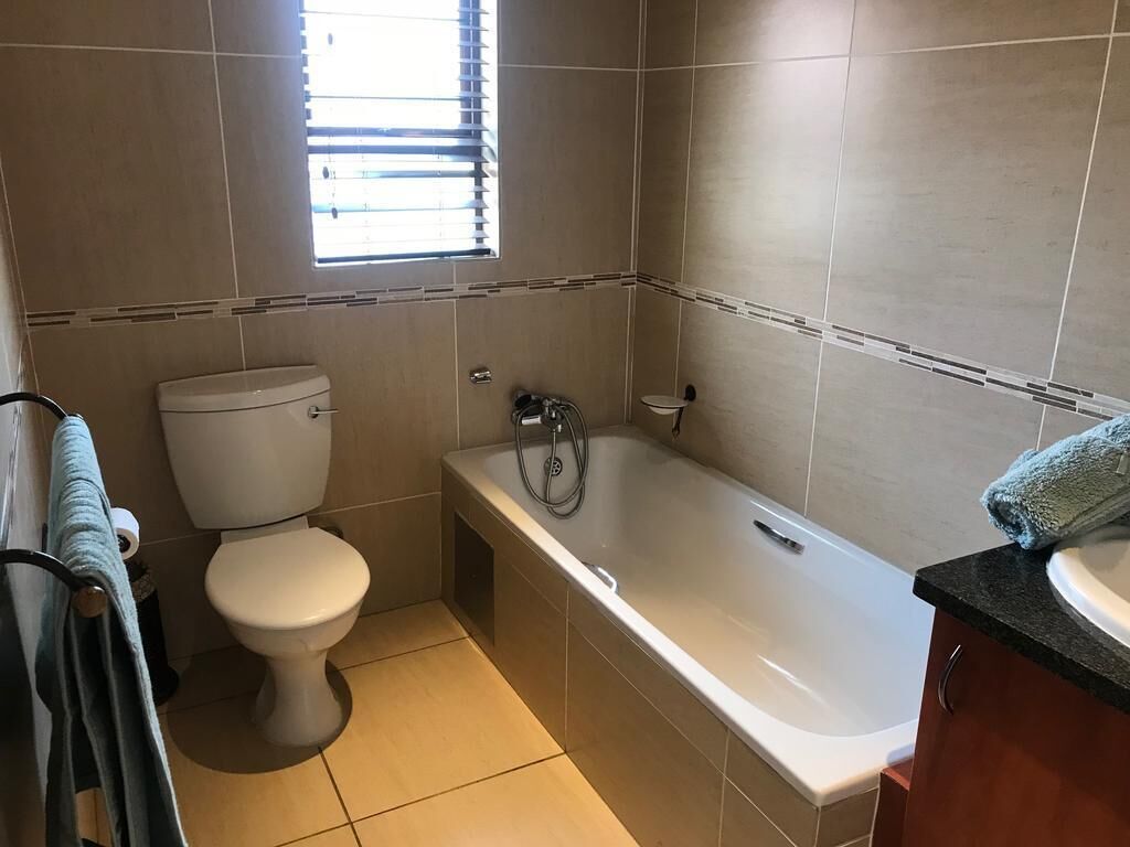 A bathroom with a toilet, bathtub, and sink.