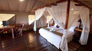 A tented room with a four-poster bed, a wooden desk, and a chair. - Rain Farm Game Lodge (Ballito)