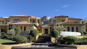 A multi-story building with a central entrance, balconies, and a stone facade. - Bella Casa Guesthouse (Sandton)