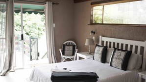 Una habitación de hotel con una cama, una silla, una mesa y una ventana.