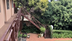 A landscaped garden with a stone pathway, a metal staircase, and a variety of plants.