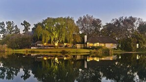 Une propriété au bord du lac, comprenant une maison, un kiosque et un étang.