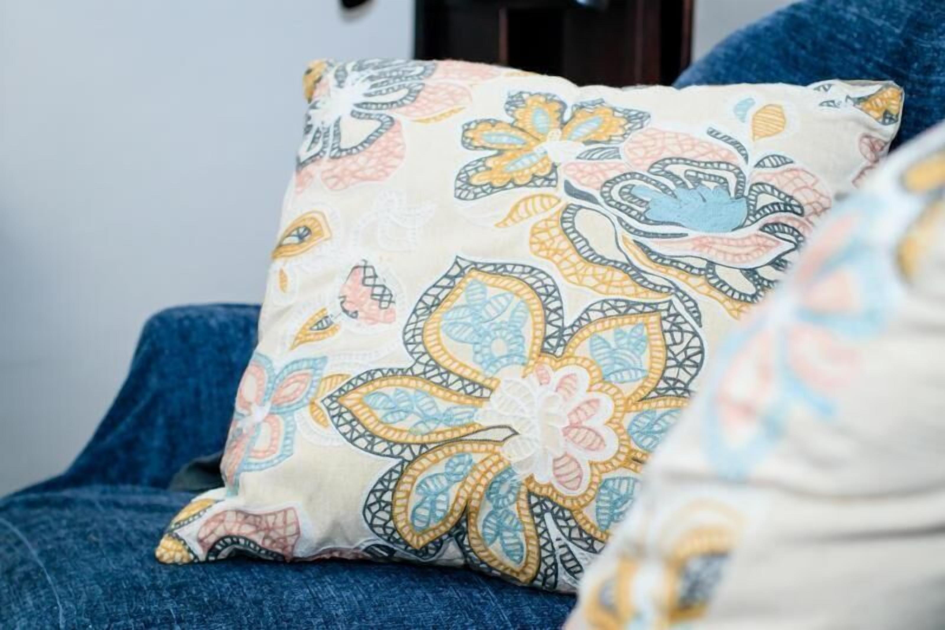 A pillow with a floral pattern on a chair.