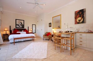 Cozy retreat with a neatly made bed, sofa, and dining area, perfect for a comfortable stay.