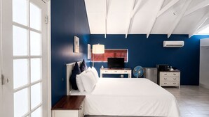 Een slaapkamer met een bed, nachtkastjes, een televisie en een verwarming.