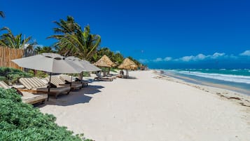 Plage, sable blanc, parasols, serviettes de plage
