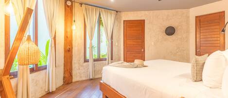 A bedroom with a wooden bed, a ceiling fan, and curtains.