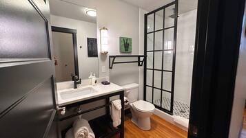 A modern bathroom with a sink, toilet, and walk-in shower.