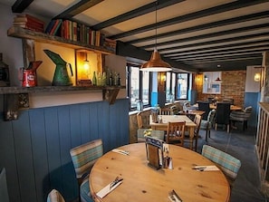 Enjoy a warm atmosphere in our restaurant, surrounded by books, pendant lights, and exposed beams.