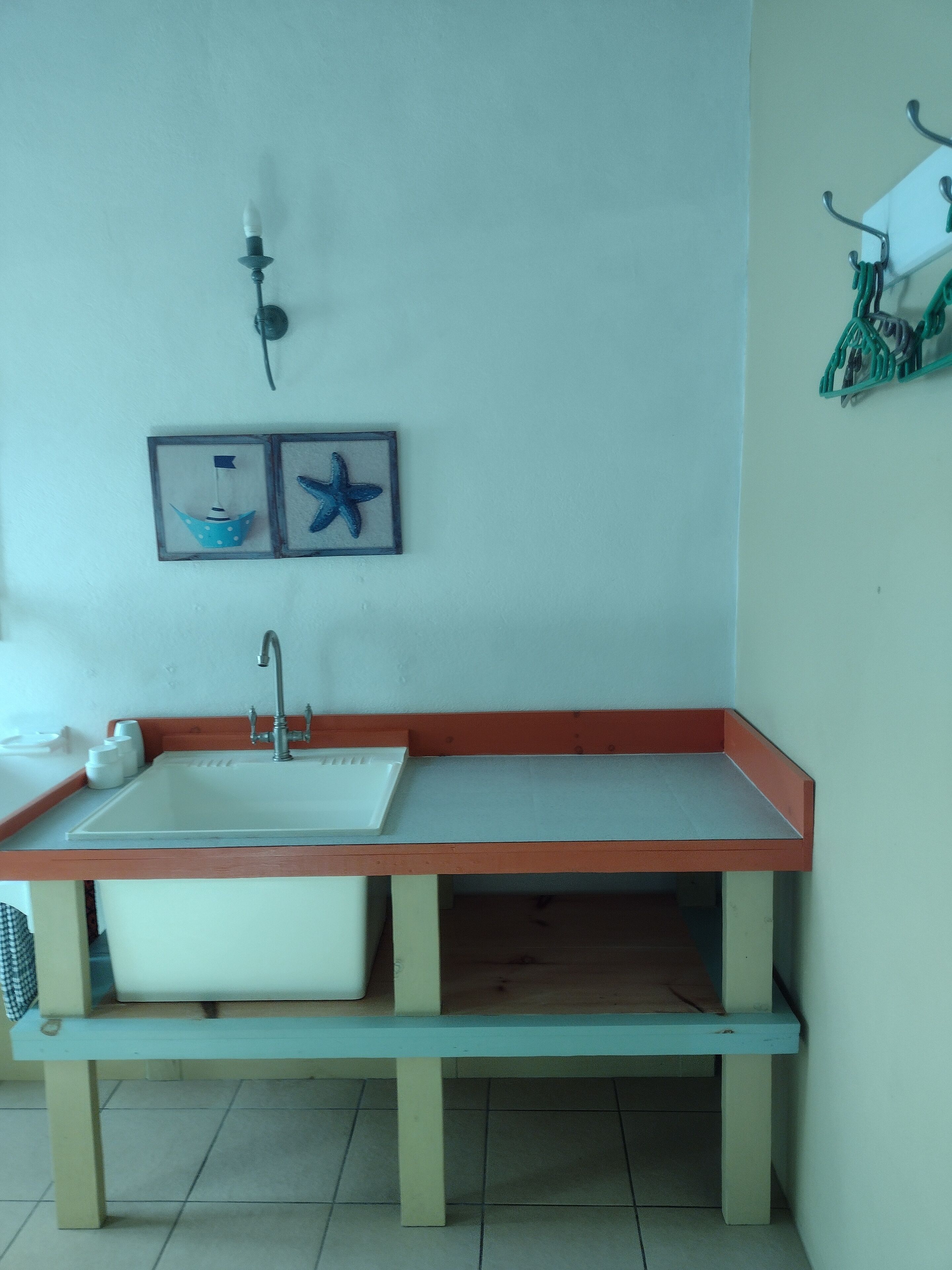 A bathroom with a sink, mirror, and a shelf with toiletries.