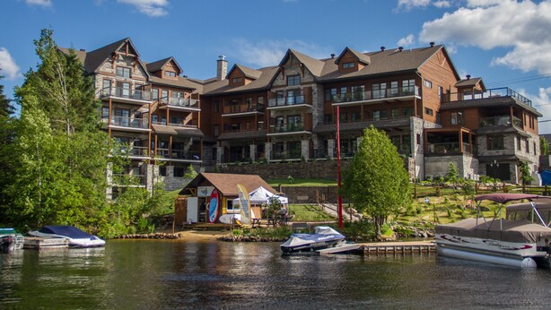 A multi-story hotel with a dock and boats. - Le Viking Resort & Marina (Sainte-Marguerite-du-Lac-Masson)