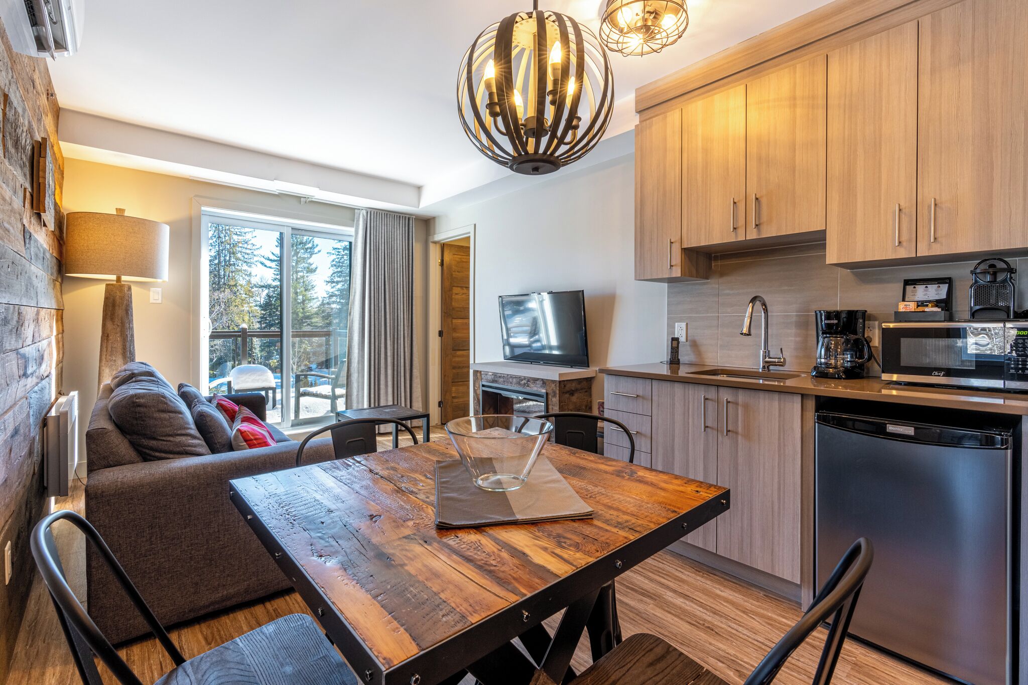 Una cocina moderna con armarios de madera, una mesa de comedor y un televisor.