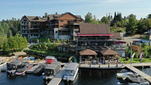 A waterfront hotel with multiple buildings, docked boats, and a restaurant area. - Le Viking Resort & Marina (Sainte-Marguerite-du-Lac-Masson)