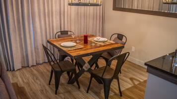 Een eetruimte met een houten tafel, zes stoelen en een kroonluchter.