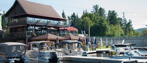 A waterfront building with multiple decks and outdoor seating areas.
