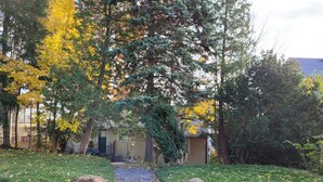 A pathway leading to a building surrounded by trees with yellow leaves. - Niagara Riverview Inn (Niagara Falls)