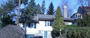 A two-story house with a garage, surrounded by tall trees and a well-maintained lawn. - Niagara Riverview Inn (Niagara Falls)