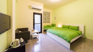 Una habitación con cama, escritorio, silla, televisor y aire acondicionado.