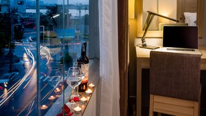 Un balcon avec un ordinateur portable, des bougies et des bouteilles de vin.