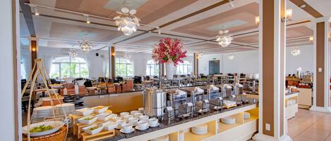 A buffet area with a variety of food stations, including a salad bar, hot and cold beverages, and a coffee station.