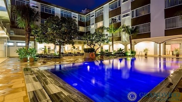 Una piscina al aire libre, sombrillas, tumbonas