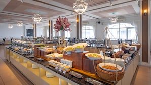 Un buffet proposant une variété de plats et agrémenté d’un grand arrangement floral.