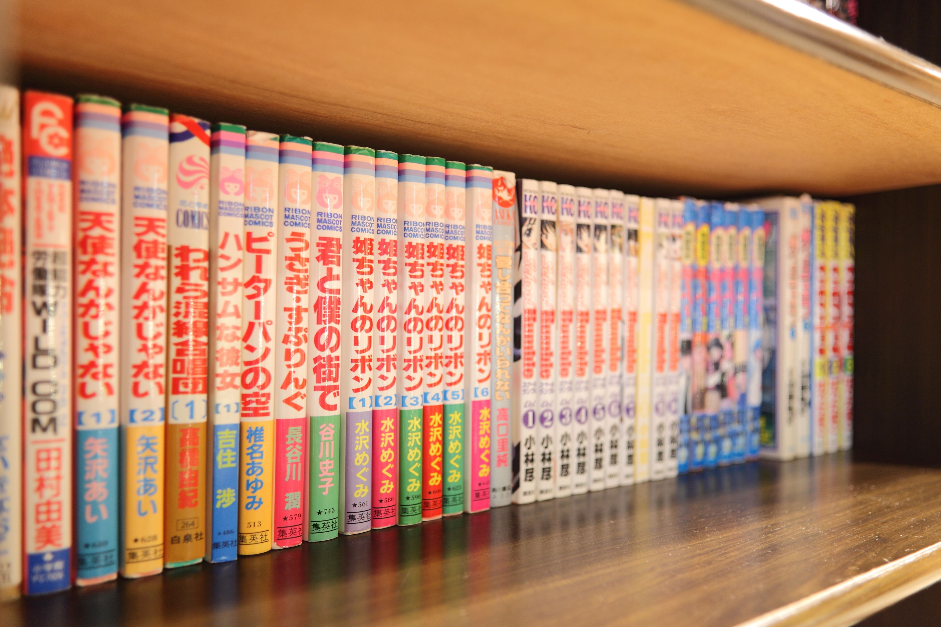 A shelf with a row of books with Japanese text.