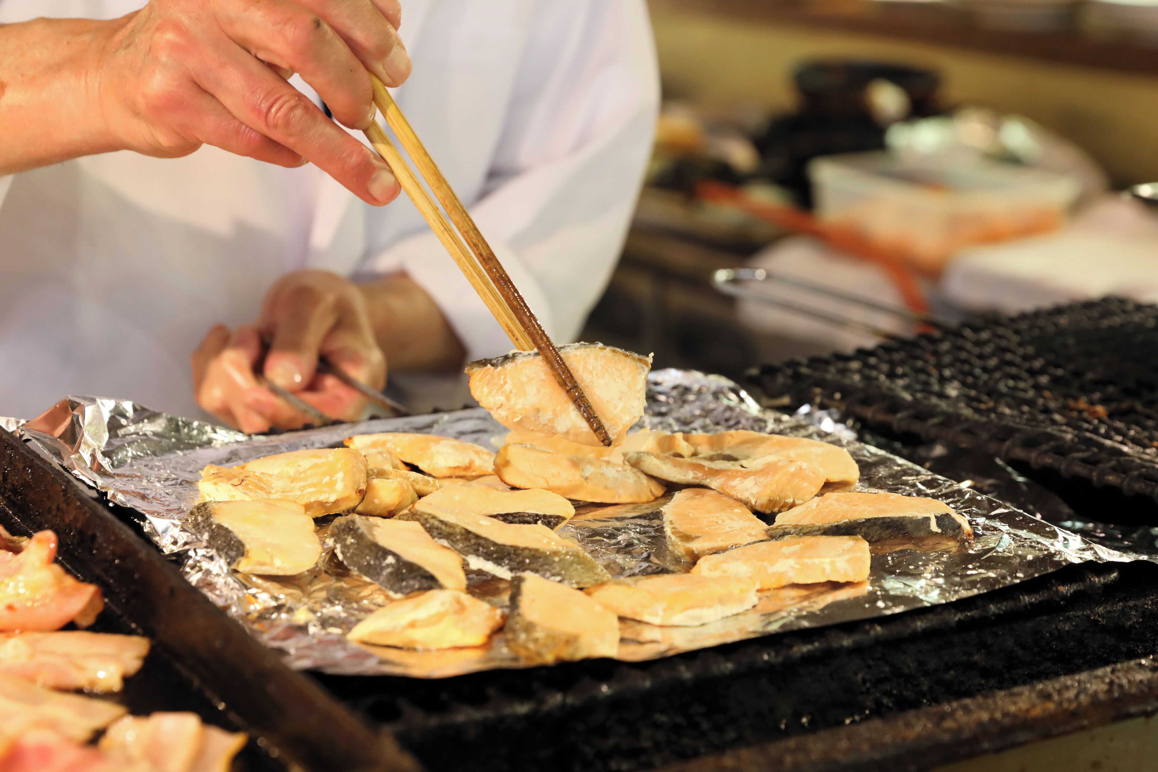 A person grilling fish on a grill.