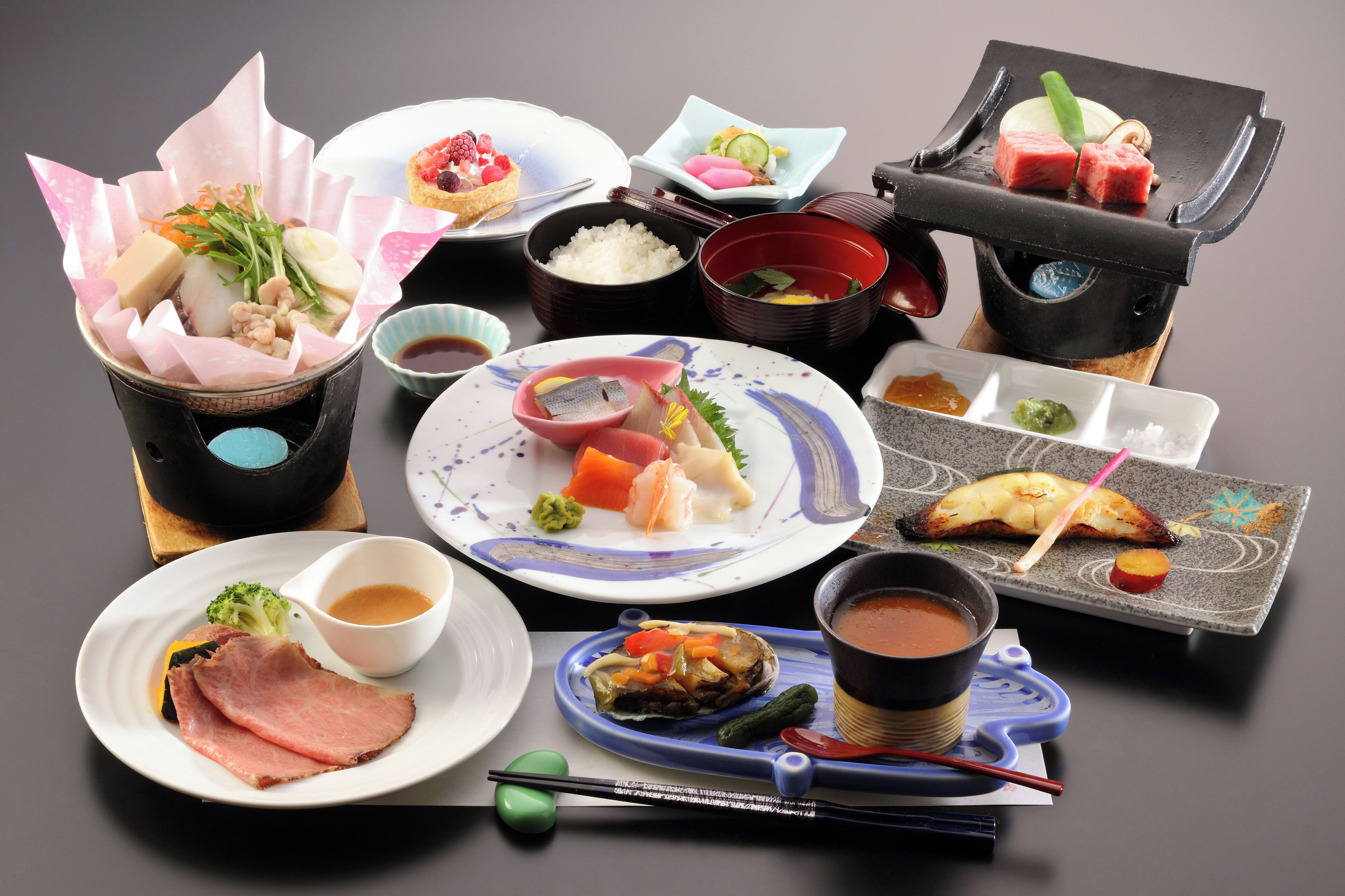 A variety of Japanese dishes including sushi, sashimi, and rice bowls, arranged on a table.