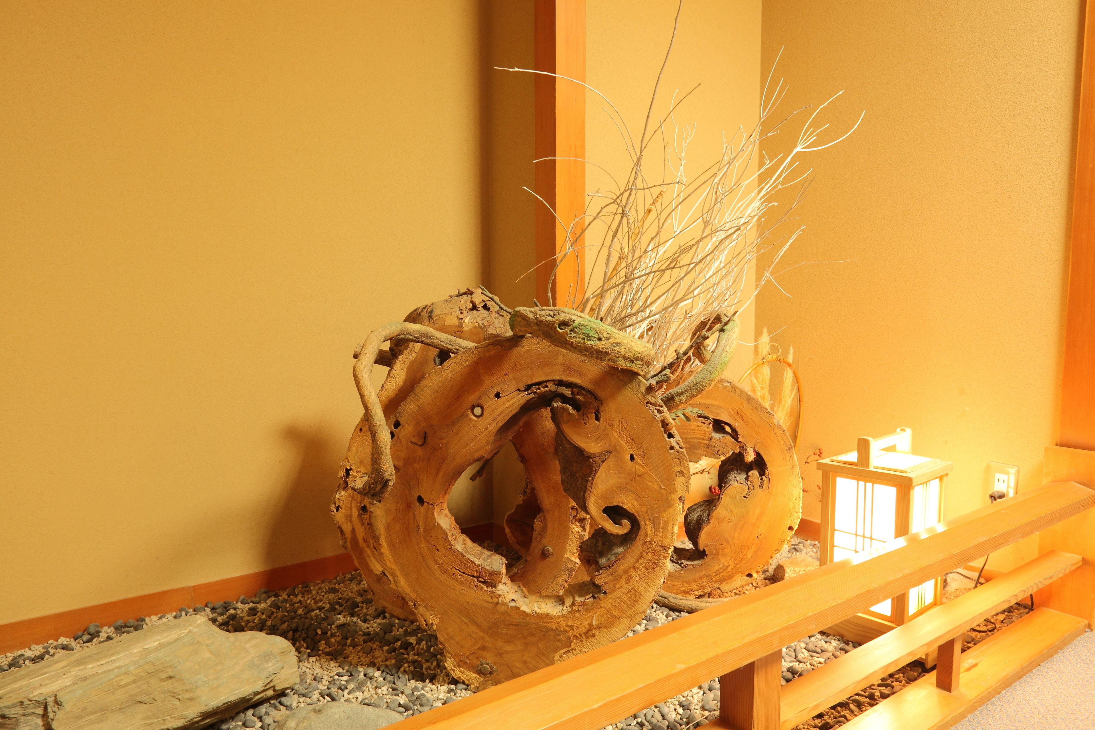 A wooden sculpture with branches in a corner.