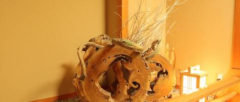 A wooden sculpture with branches in a corner.