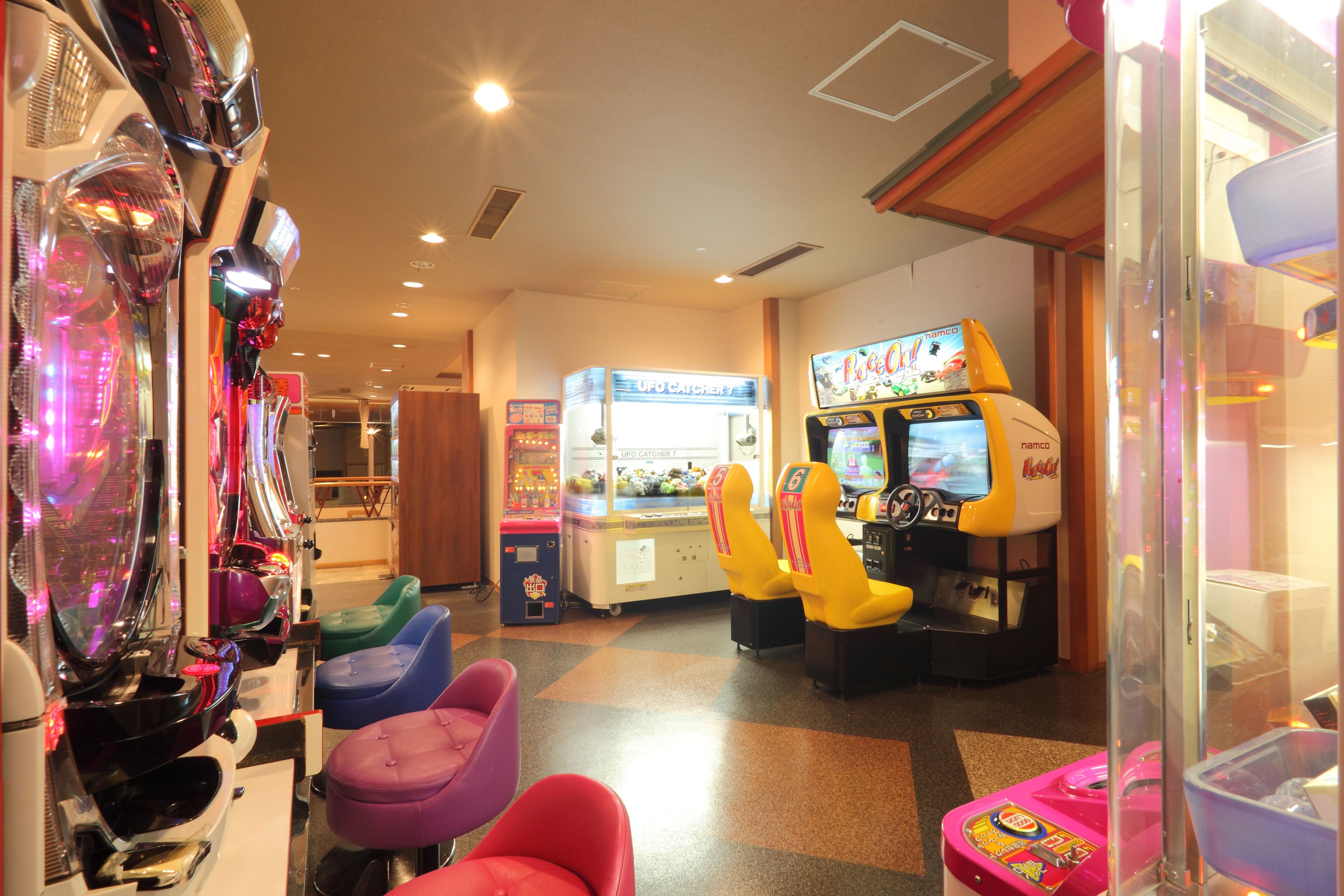 An arcade with claw machines and racing games.