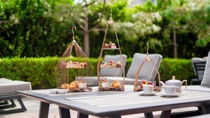 A table set outdoors with tiered dessert stands and tea sets. - Artyzen Habitat Dongzhimen Beijing (Beijing)