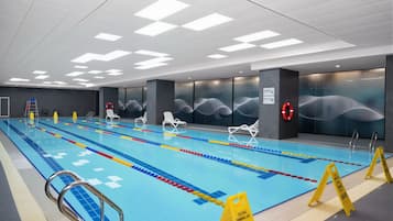 A swimming pool with lane dividers, lifebuoys, and a teaching lane sign.